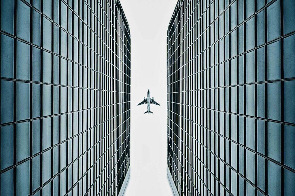 Ein Flugzeug fliegt über Bürogebäude hinweg